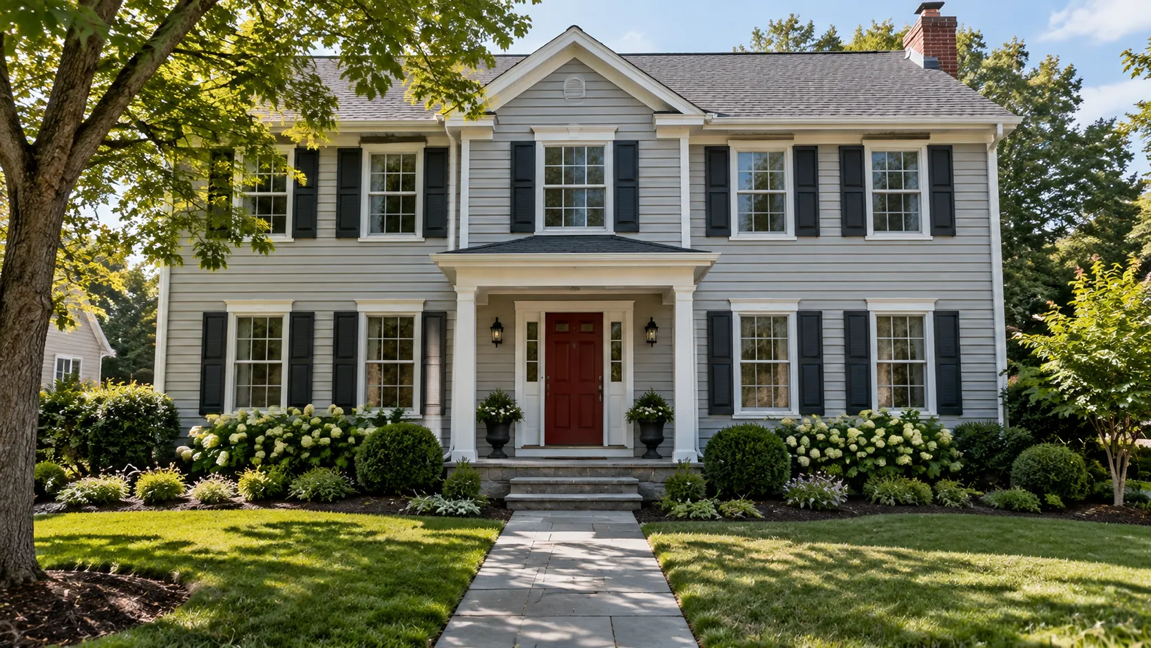 Freshly painted light grey vinyl siding with white trim and a deep red front door on a two-story New Jersey colonial